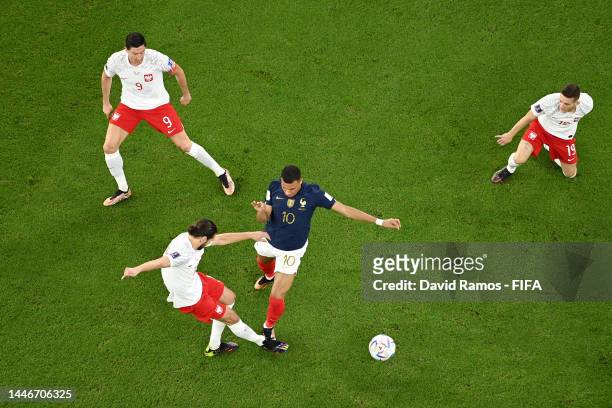 Kylian Mbappe of France battles for possession with Grzegorz Krychowiak of Poland during the FIFA World Cup Qatar 2022 Round of 16 match between...