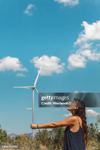 woman standing in front of wind turbine - perspective artificielle photos et images de collection