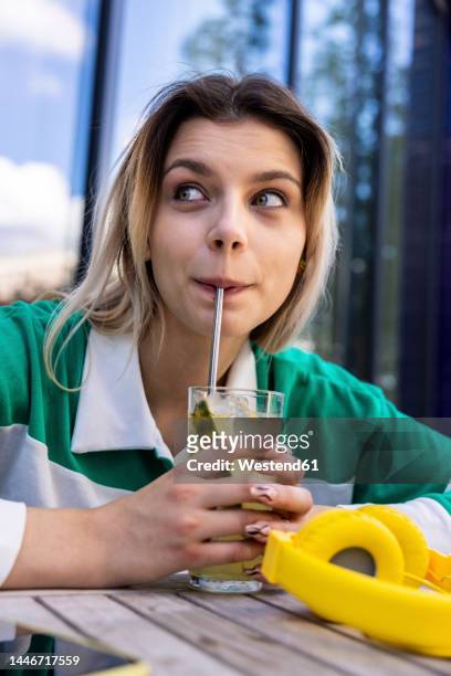 young woman drinking from glass with stainless steel straw - metal straw stock pictures, royalty-free photos & images