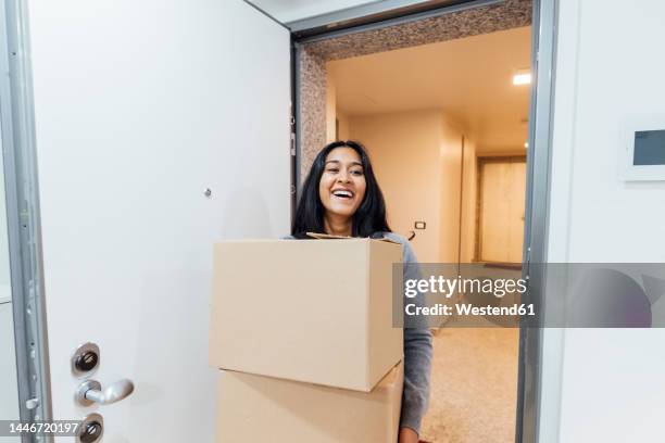 happy young woman holding boxes at home - carrying box stock pictures, royalty-free photos & images