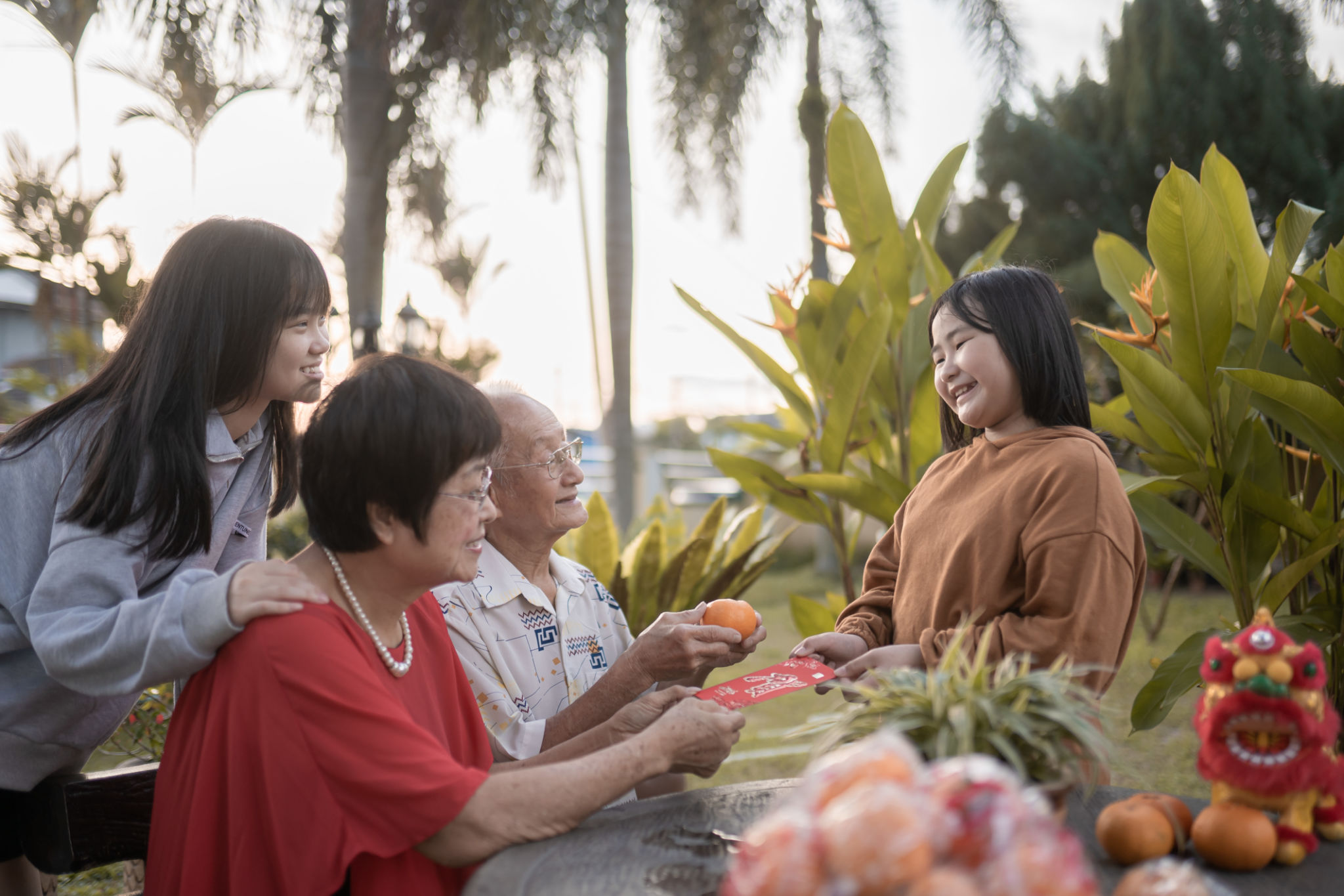 Asian grandparents giving red envelops to grandchild joyfully in Chinese New Year Asian grandparents giving red envelops to grandchild joyfully in Chinese New Year