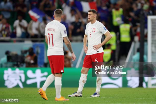 Kamil Grosicki and Krystian Bielik of Poland react after Kylian Mbappe of France scored their sides third goal during the FIFA World Cup Qatar 2022...