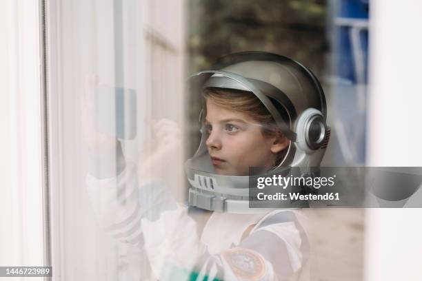 girl wearing space costume photographing through smart phone at home - astronaut kid stock pictures, royalty-free photos & images