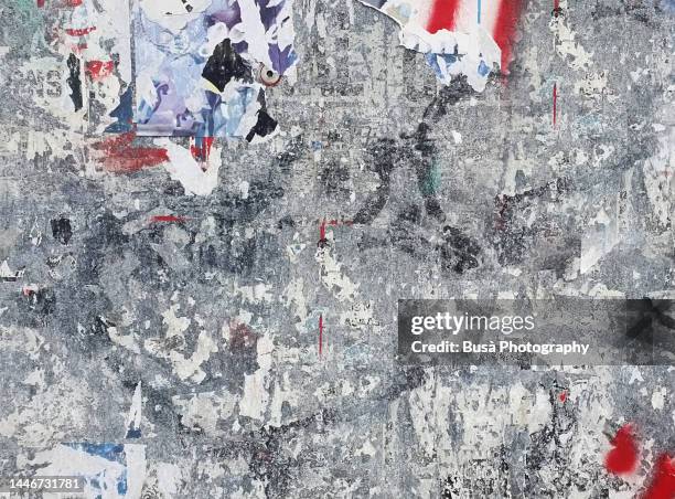 scratched layers of posters and placards on a street wall - stress resistant stockfoto's en -beelden