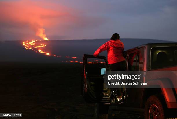 Woman watches the eruption of the Mauna Loa volcano on December 04, 2022 near Hilo, Hawaii. For the first time in nearly 40 years, the Mauna Loa...