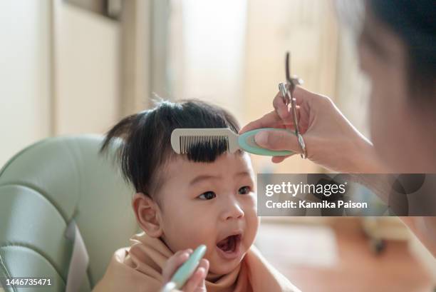 little cute asian baby boy getting his first haircut - new hairstyle stock pictures, royalty-free photos & images