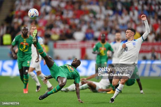 Phil Foden of England battles for possession with Youssouf Sabaly of Senegal during the FIFA World Cup Qatar 2022 Round of 16 match between England...