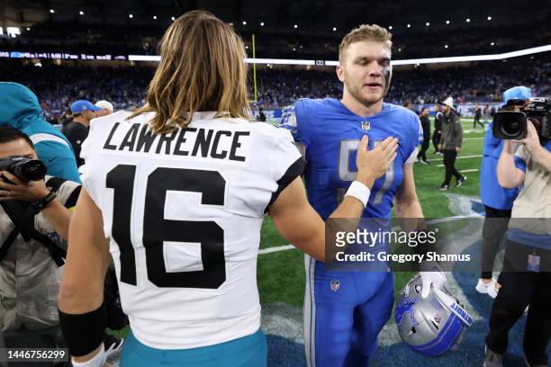 Trevor Lawrence of the Jacksonville Jaguars greets Aidan Hutchinson of the Detroit Lions on the field after the game at Ford Field on December 04,...