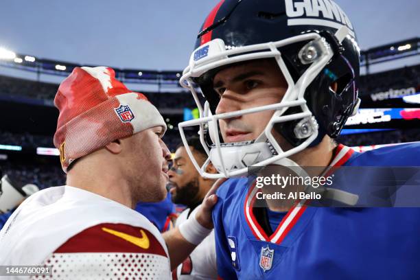Taylor Heinicke of the Washington Commanders and Daniel Jones of the New York Giants embrace after a game at MetLife Stadium on December 04, 2022 in...