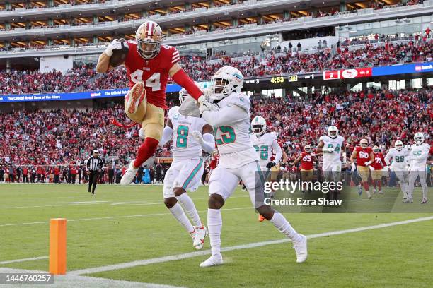 Kyle Juszczyk of the San Francisco 49ers leaps past Xavien Howard of the Miami Dolphins while scoring a touchdown during the first quarter at Levi's...