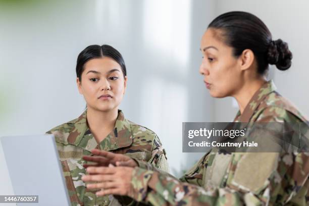 mujer soldado reunida en el cargo con el oficial al mando. las mujeres usan ropa de camuflaje - military recruitment fotografías e imágenes de stock