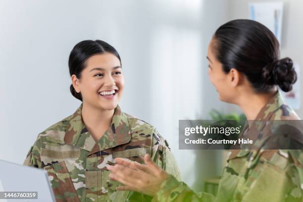 female soldier meeting in office with commanding officer. women are wearing camo clothing - military uniform stock pictures, royalty-free photos & images