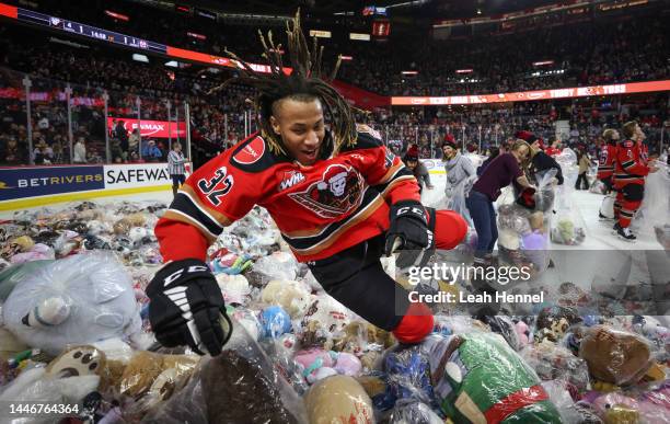 London Hoilett of the Calgary Hitmen jumps into a pile of bears after scoring on the Moose Jaw Warriors during the 27th annual ENMAX Teddy Bear Toss...