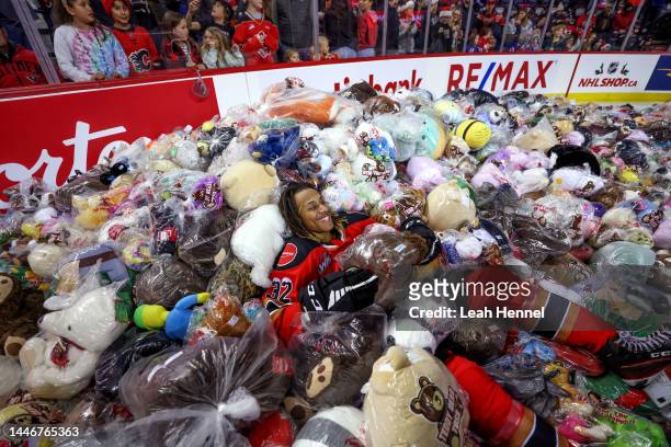 London Hoilett of the Calgary Hitmen jumps into a pile of bears after scoring on the Moose Jaw Warriors during the 27th annual ENMAX Teddy Bear Toss...