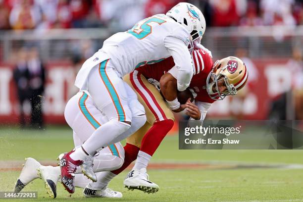 Jaelan Phillips of the Miami Dolphins and Jerome Baker of the Miami Dolphins sack Jimmy Garoppolo of the San Francisco 49ers during the first quarter...