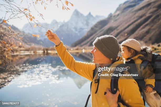 dad with baby walking outdoors and exploring nature around. child education in travel - vida sencilla fotografías e imágenes de stock