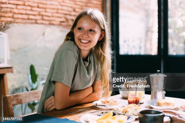 a happy beautiful blonde girl having breakfast - 14 year old blonde girl stock pictures, royalty-free photos & images