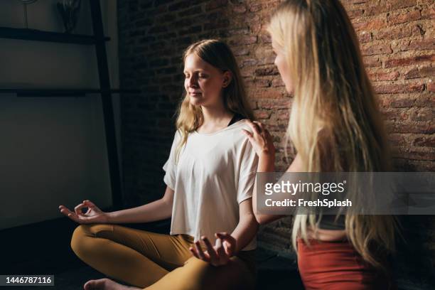 an unrecognizable yoga instructor teaching yoga to a teenager - teenager yoga stock pictures, royalty-free photos & images