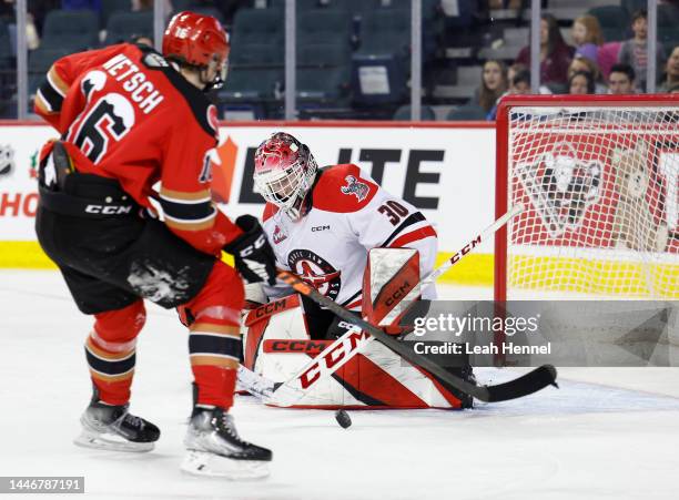 Jackson Unger of the Moose Jaw Warriors blocks a shot from Carson Wetsch of the Calgary Hitmen during the third period of the game in the 27th annual...