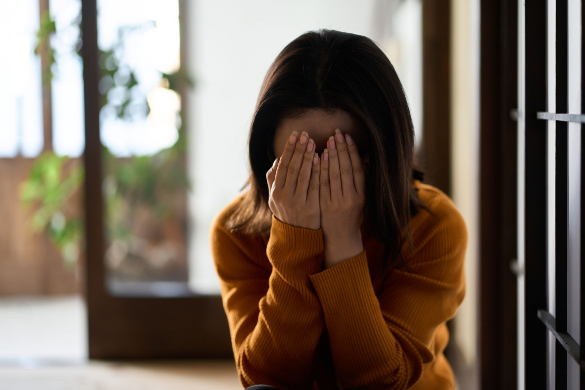 woman covering her face with both hands woman covering her face with both hands