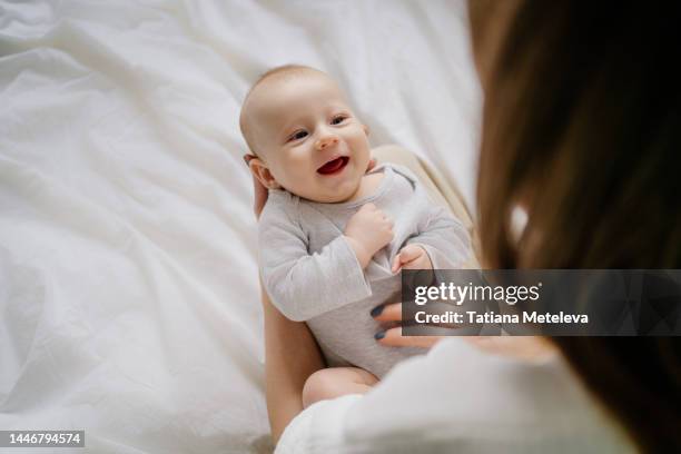 surrogate motherhood. small baby is lying on mother hands and looking around. - surrogacy stock pictures, royalty-free photos & images