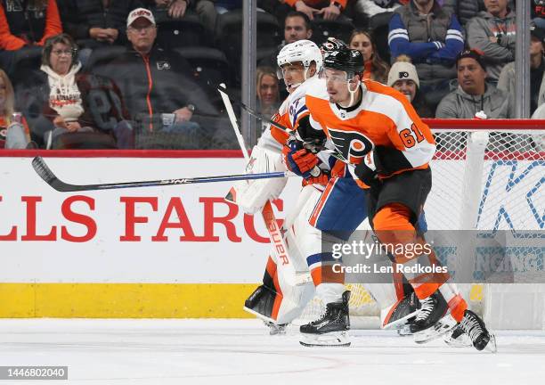Justin Braun and Carter Hart of the Philadelphia Flyers defend their goal against Anders Lee of the New York Islanders at the Wells Fargo Center on...