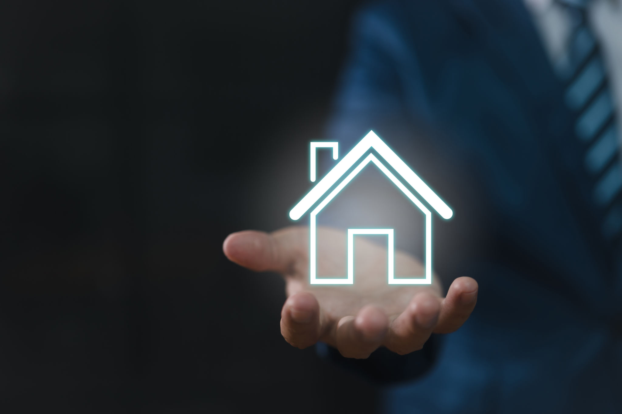 Real estate concept: a businessman holding an icon of a house. house available Property insurance and security concept Man protective gesture and house symbol Real estate concept: a businessman holding an icon of a house. house available Property insurance and security concept Man protective gesture and house symbol