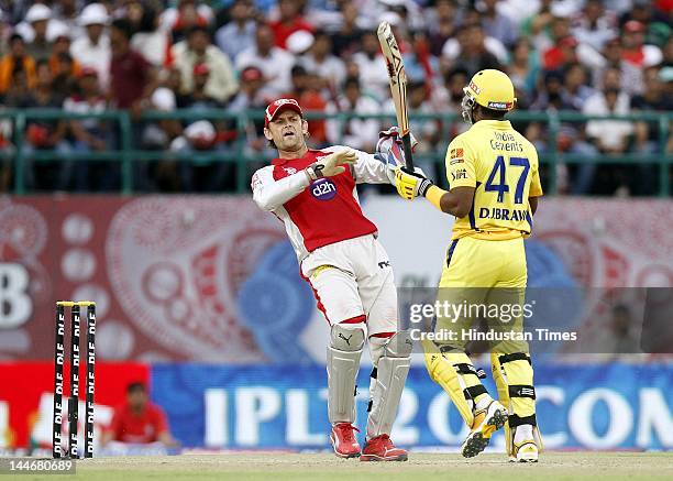 Kings XI Punjab captain Adam Gilchrist trying to save himself from the swinging bat of Chennai Super Kings batsman Dwayne Bravo during IPL Twenty 20...