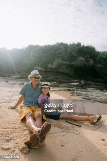 grandfather and granddaughter having a good time on beach - granddaughter ストックフォトと画像