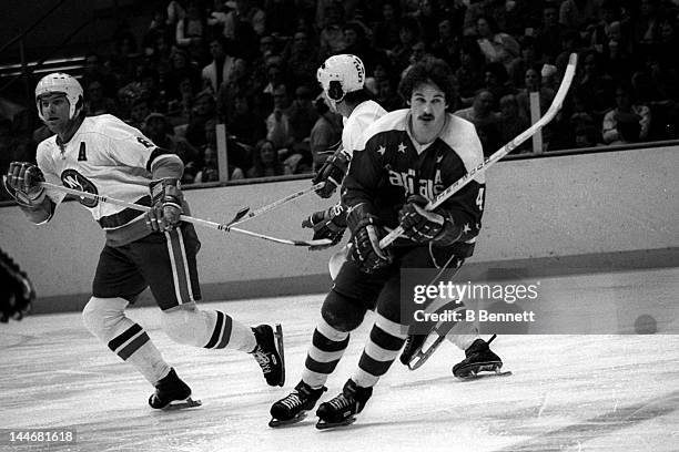 Bill Mikkelson of the Washington Capitals and Garry Howatt of the New York Islanders skate on the ice on Febuary 8, 1975 at the Nassau Coliseum in...