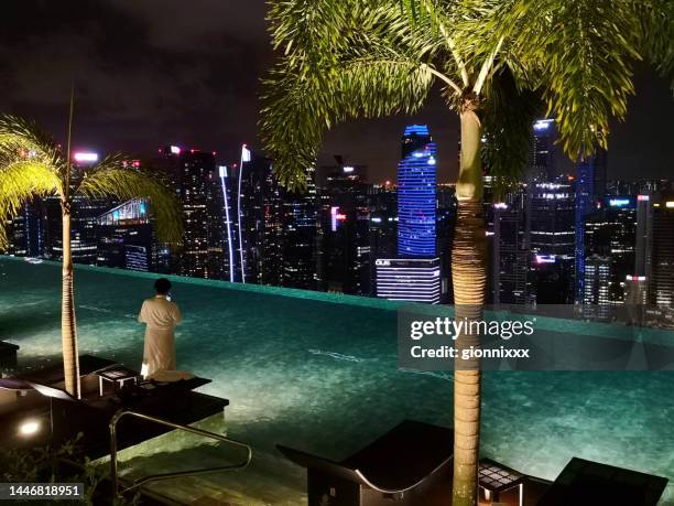 la piscina infinita en marina bay sands por la noche - pool marina bay sands hotel singapore fotografías e imágenes de stock