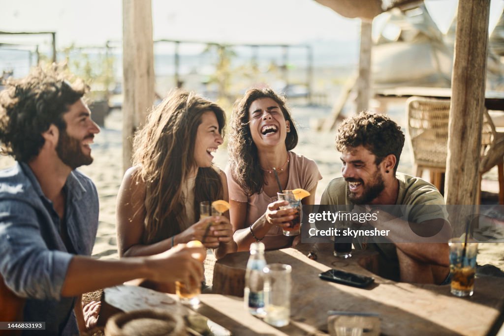 Fröhliche Paare unterhalten sich am Sommertag an einer Strandbar.
