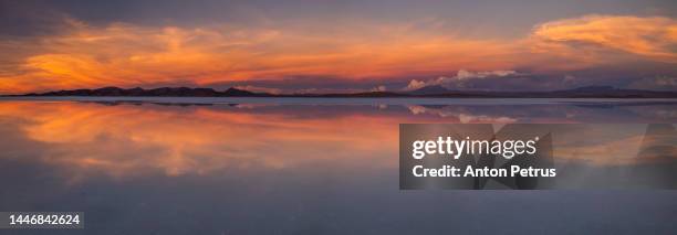 sunset at salar de uyuni in the rainy season, aitiplano, bolivia - luminous lagoon stock pictures, royalty-free photos & images