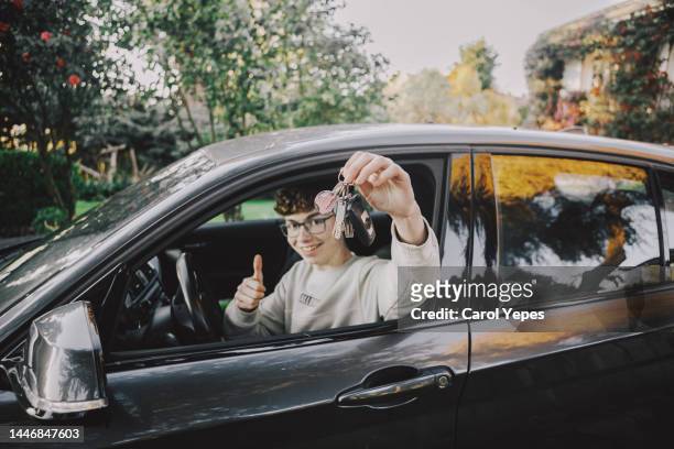 boy inside car with new driving license - car ownership stock-fotos und bilder