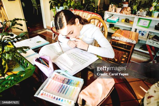 medium shot of teenager studying and doing homeworks - etui stockfoto's en -beelden
