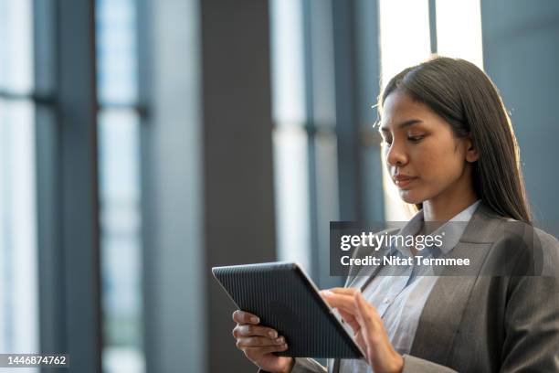 the virtual workplace helps flexibility and innovation are key. a young asian businesswoman uses a tablet computer to access business data on a cloud network in a business co-working space. - security code 個照片及圖片檔