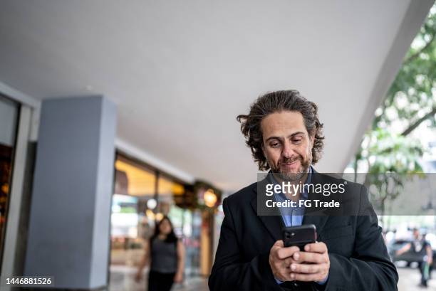 businessman using mobile phone in the city - generation x stock pictures, royalty-free photos & images