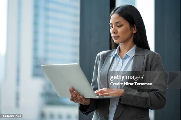 cloud computing made easy in remote working. side view of a young asian businesswoman using a laptop computer to remotely access work during business travel. - business model stock pictures, royalty-free photos & images