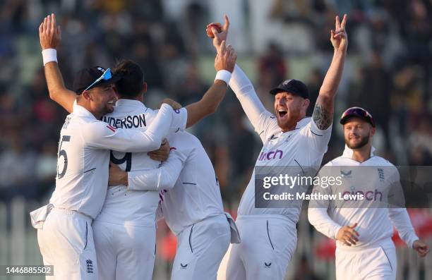 James Anderson of England celebrates with teammates Will Jacks and Ben Stokes after taking the wicket of Haris Rauf of Pakistan during day five of...