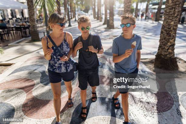 mother and teenagers walking in the wave walkway in alicante - alicante stock pictures, royalty-free photos & images