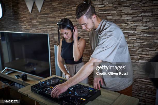 young man and woman operating mixing console - unterhaltungsberuf stock-fotos und bilder