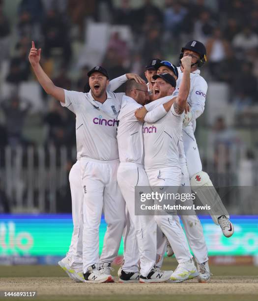 Ollie Robinson, Jack Leach and Ben Stokes of England celebrate winning the First Test Match between Pakistan and England at Rawalpindi Cricket...