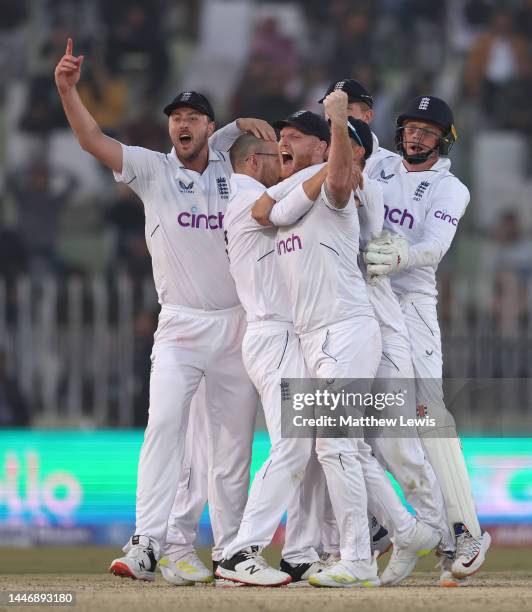 Ollie Robinson, Jack Leach and Ben Stokes of England celebrate winning the First Test Match between Pakistan and England at Rawalpindi Cricket...