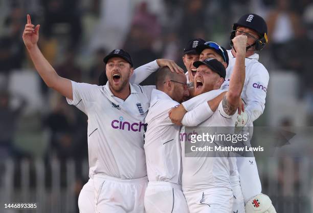 Ollie Robinson, Jack Leach and Ben Stokes of England celebrate winning the First Test Match between Pakistan and England at Rawalpindi Cricket...