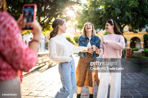 young friends filming using mobile phone outdoors - historische wijk stockfoto's en -beelden