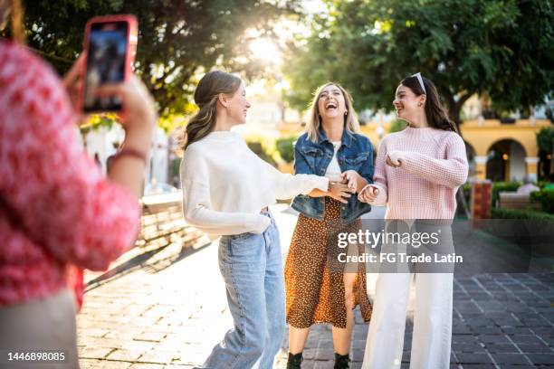 young friends filming using mobile phone outdoors - student wellbeing stock pictures, royalty-free photos & images
