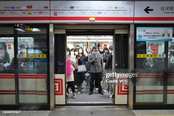 Citizens wearing masks take a subway train on December 5, 2022 in Zhengzhou, Henan Province of China. Negative nucleic acid testing results are not...