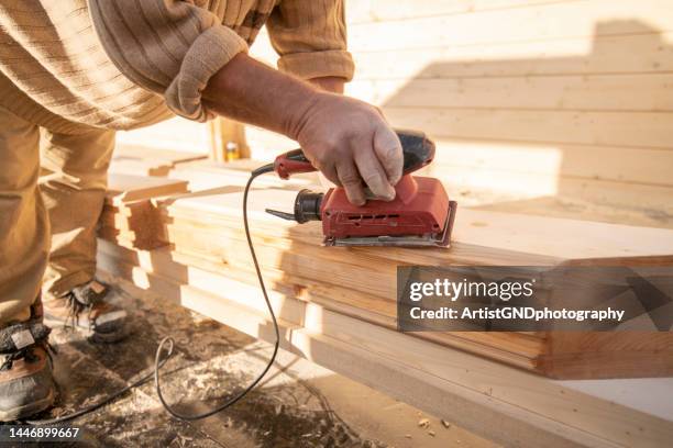 close-up of worker grinding wooden plank. - handyman stock pictures, royalty-free photos & images