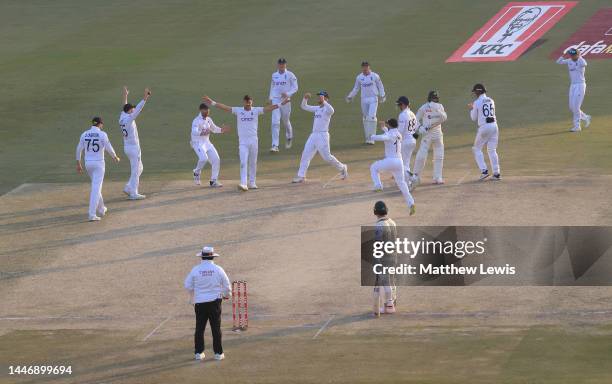 James Anderson of England celebrates with teammates after taking the wicket of Haris Rauf of Pakistan during day five of the First Test Match between...