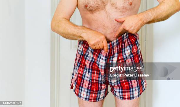 man pointing down his boxer shorts - condiloma fotografías e imágenes de stock